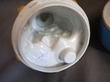 a close up of a white and blue vase with a cat on it
