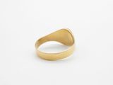 a close up of a gold ring on a white surface