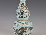 un vase bleu orné d'un dragon, posé sur une table