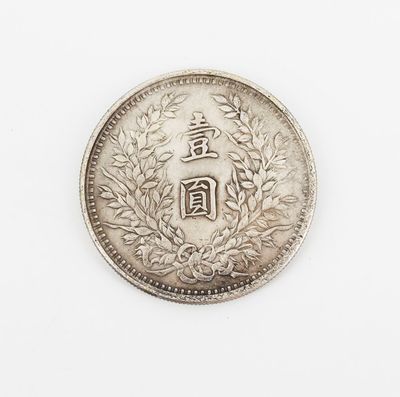 a silver coin on a white surface with a chinese writing on it