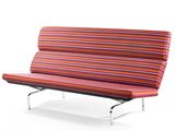 canapé-futon rayé avec des pieds en métal et un coussin rouge