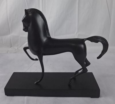 statue d'un cheval noir sur un socle noir, sur fond blanc