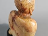 a figurine of a bird sitting on a black stand