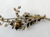 a gold flower brooch on a white surface