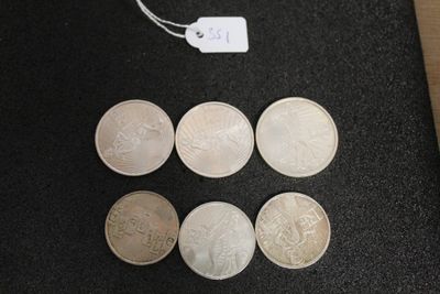 six different types of coins on a black surface with a price tag