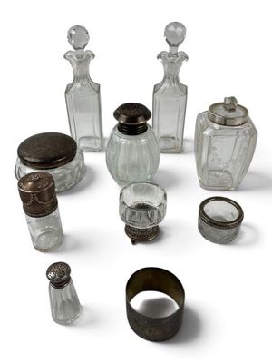 a group of glass bottles and a ring on a white surface