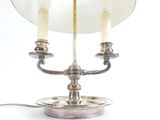 une lampe de table en argent sur laquelle sont posées deux bougies