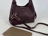 un sac à main et un portefeuille en cuir violet posés sur une surface blanche