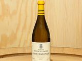 une bouteille de vin posée sur un tonneau