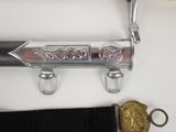 a silver sword and other items on a white table