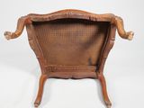 an old wooden chair with wicker back and arms on a white background
