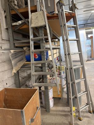 une échelle appuyée contre un mur, à côté d'une boîte