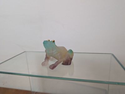une table en verre sur laquelle se trouve une figurine de grenouille