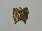 a gold butterfly that is sitting on a white surface
