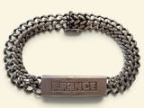 a close up of a bracelet with a bar on it