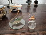 a glass swan figurine sitting on a table next to a glass bottle