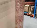 a marble pedestal with a black base in a warehouse