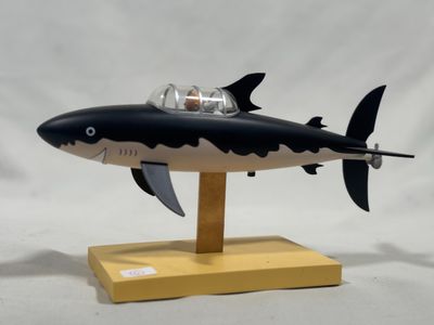 a toy shark that is sitting on a wooden stand