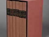 the three books are lined up in a row on a gray surface