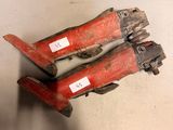 pair of red and black hand tools sitting on top of a white surface