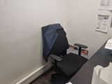 a desk with a computer and a chair in the corner