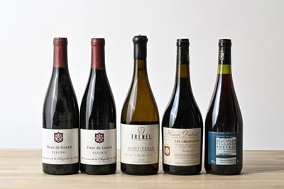 six bouteilles de vin sont alignées sur une table en bois