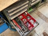 un tiroir rempli d'outils posé sur un établi dans un garage