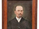 un tableau représentant un homme en costume noir et cravate, dans un cadre en bois
