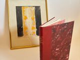 une photo d'un livre rouge posée à côté d'une photo d'un chat