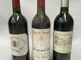 three bottles of wine are lined up on a white surface