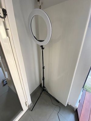 une lumière blanche posée sur un trépied dans une pièce