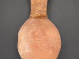 a clay vase on a black surface with a black background
