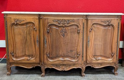 une armoire en bois avec un plateau en marbre, posée sur un sol carrelé