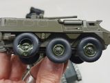 a hand holding a toy army vehicle in the palm of someone ' s hand