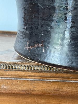 un vase noir posé sur une table en bois