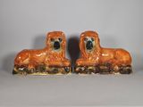 une paire de figurines de chiens en céramique posées sur un fond blanc