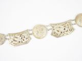 a close up of a silver bracelet with coins on a white background