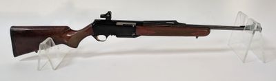 un gros plan d'un fusil posé sur un support transparent, sur une surface blanche