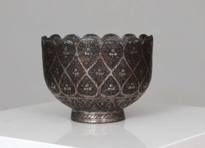 a silver bowl sitting on top of a white table