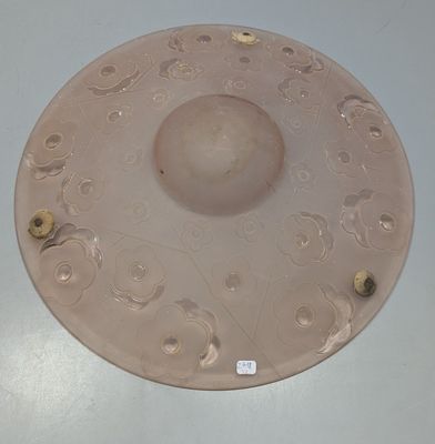 une assiette rose posée sur une table blanche, sur laquelle est collé un autocollant
