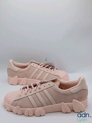 une paire de baskets Adidas roses sur fond blanc
