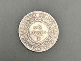 gros plan d'une pièce de monnaie en argent sur une surface noire