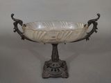 an antique glass bowl on a stand with a bird on it