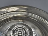 a silver plate that has a spiral design on it