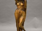 une statue antique en bronze représentant une femme portant un pot sur la tête