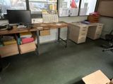 un bureau sur lequel se trouve un ordinateur, dans une pièce où il y a beaucoup de cartons