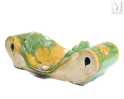 un vase vert et jaune posé sur une surface blanche