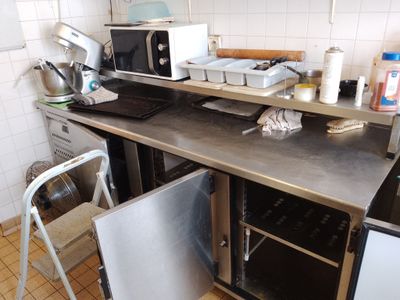 une petite cuisine équipée d'un micro-ondes et d'un lave-vaisselle posés sur le plan de travail