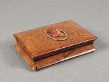 an old wooden box with a fish on it sitting on a table