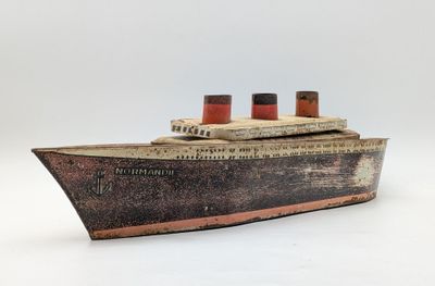 wooden model of a large boat with two red and white sails
